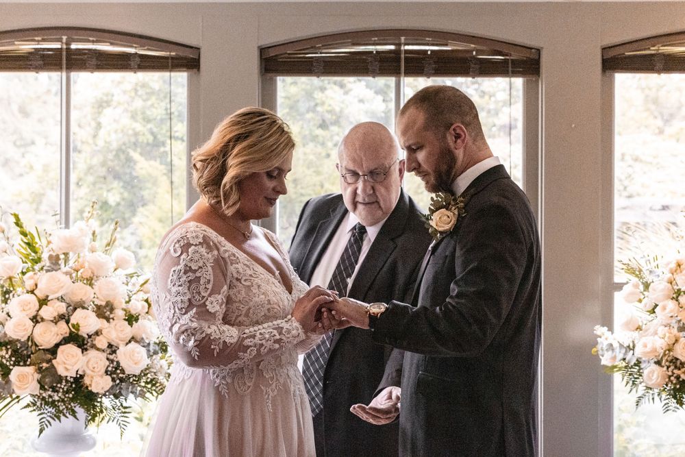 A wedding ceremony scene with soft natural light streaming through windows, featuring elegant floral arrangements in blush tones.