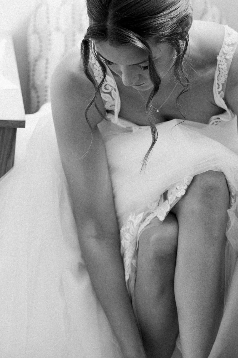 Black and white artistic photo series showing intimate details of a bride's dress and posture in four similar poses.