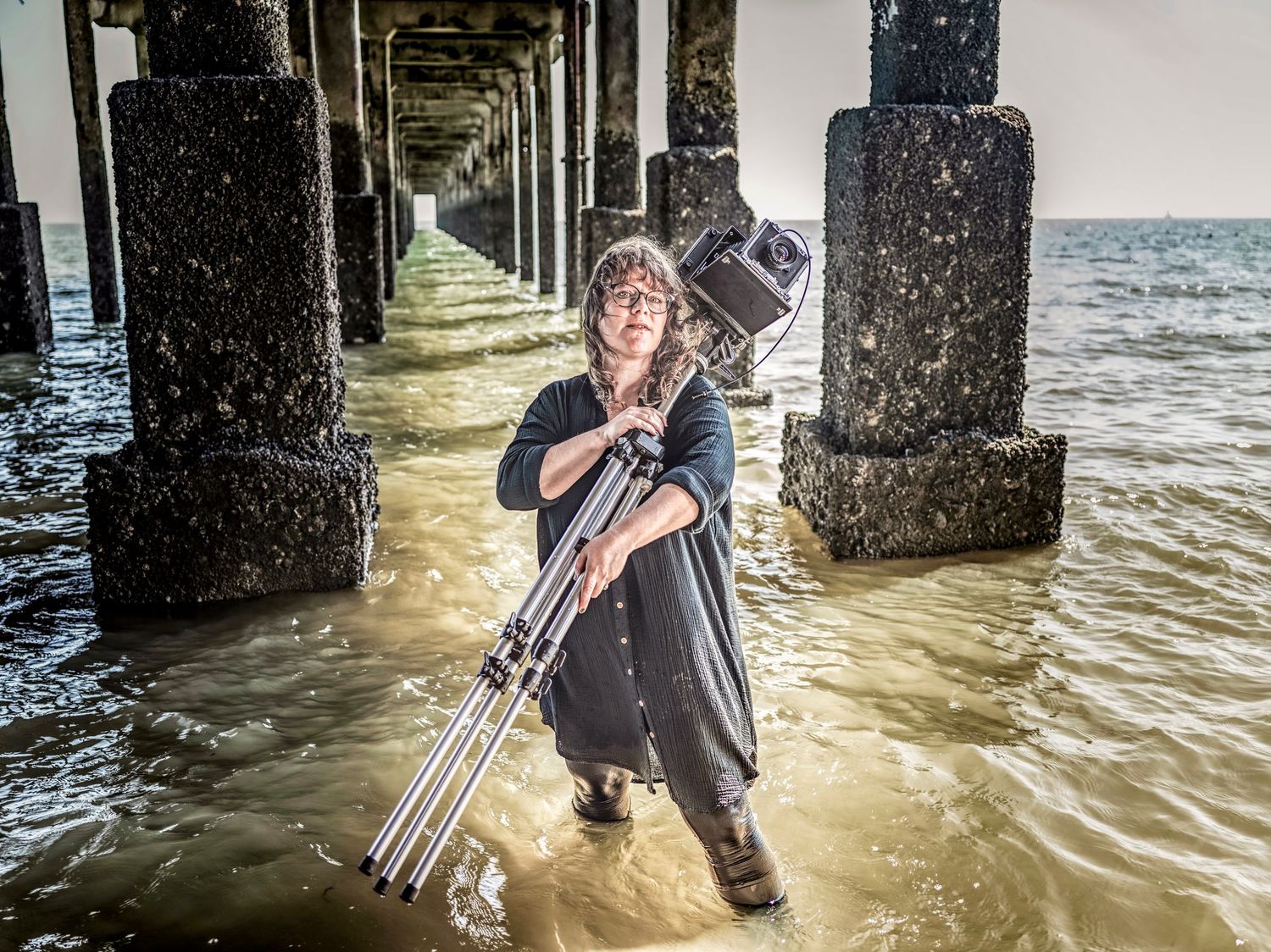 Editorial portrait of photographer teacher Amy Gladding under a pier in Felixstowe, Suffolk