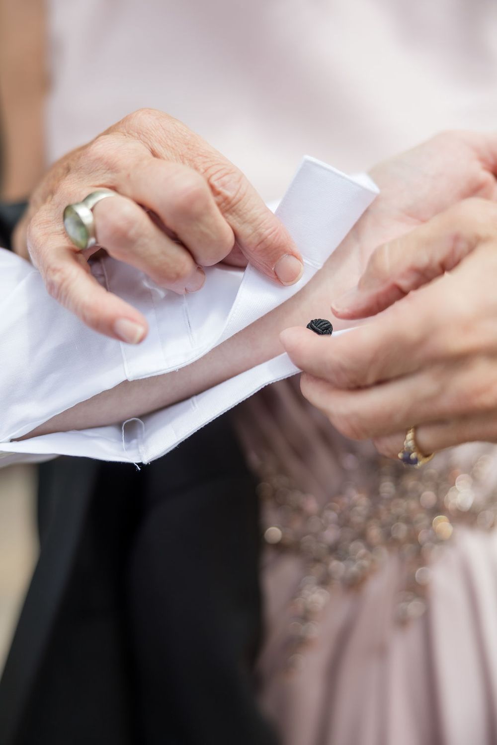 Close-up of hands exchanging paper notes during wedding ceremony.