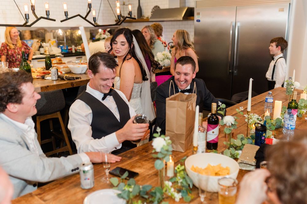 Candid moments of people dining and socializing at a rustic restaurant table decorated with greenery and bottles.
