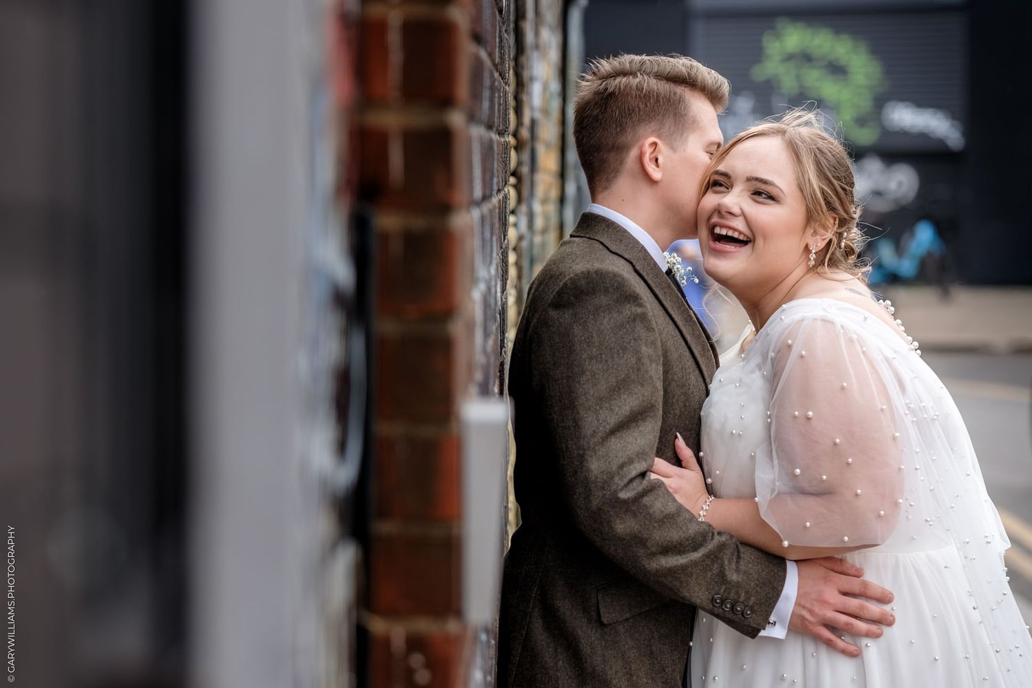 A joyful couple shares a romantic moment together on their wedding day wearing traditional bridal attire.