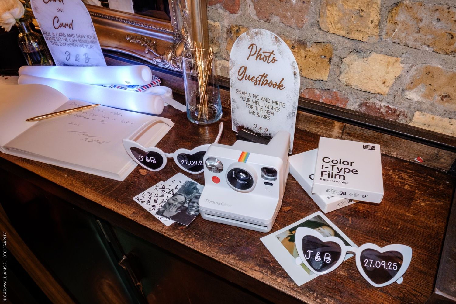 Wedding guest cards and decorative items arranged on a rustic wooden table with vintage styling.