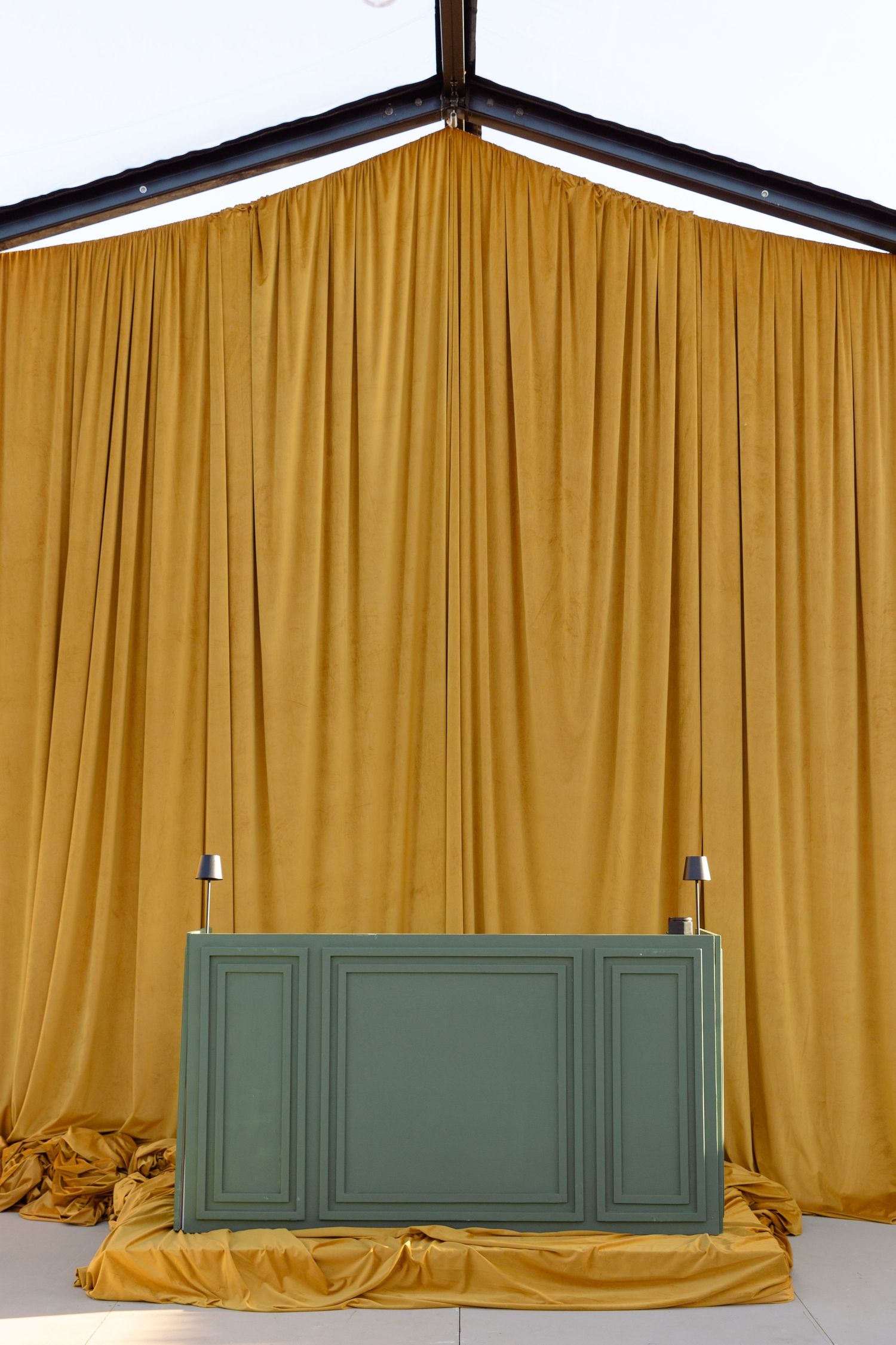 Four identical images show a yellow curtain backdrop with a sage green paneled wall section at the bottom against a white wall.