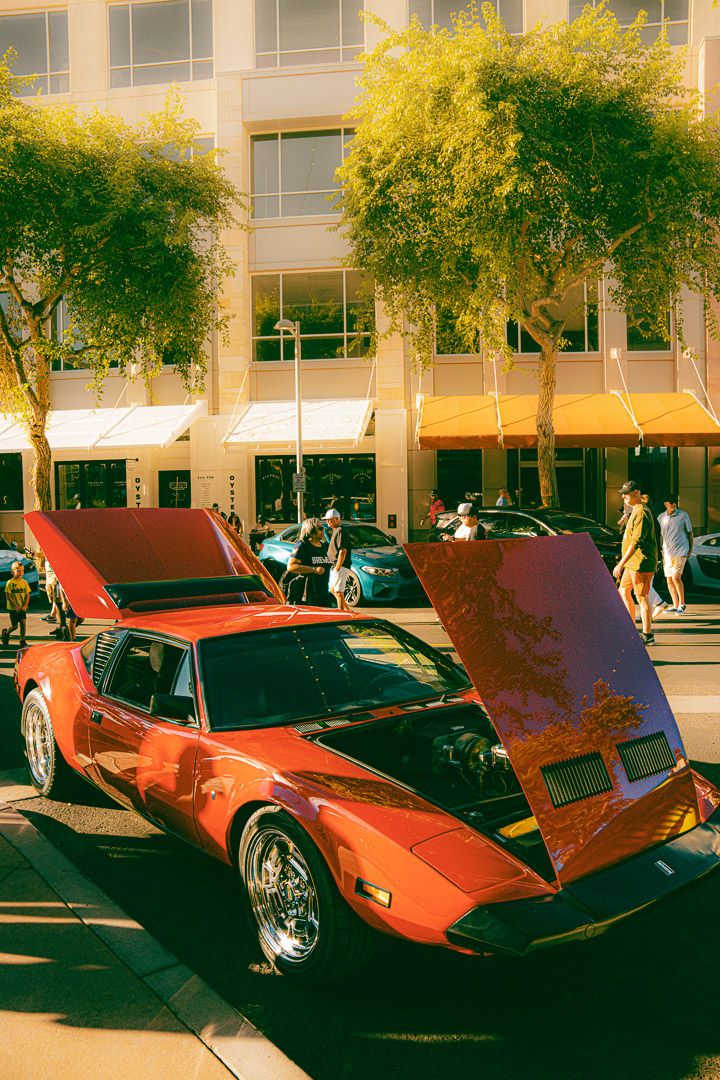 Classic red Lamborghini Countach and vintage supercars lined up at car show.