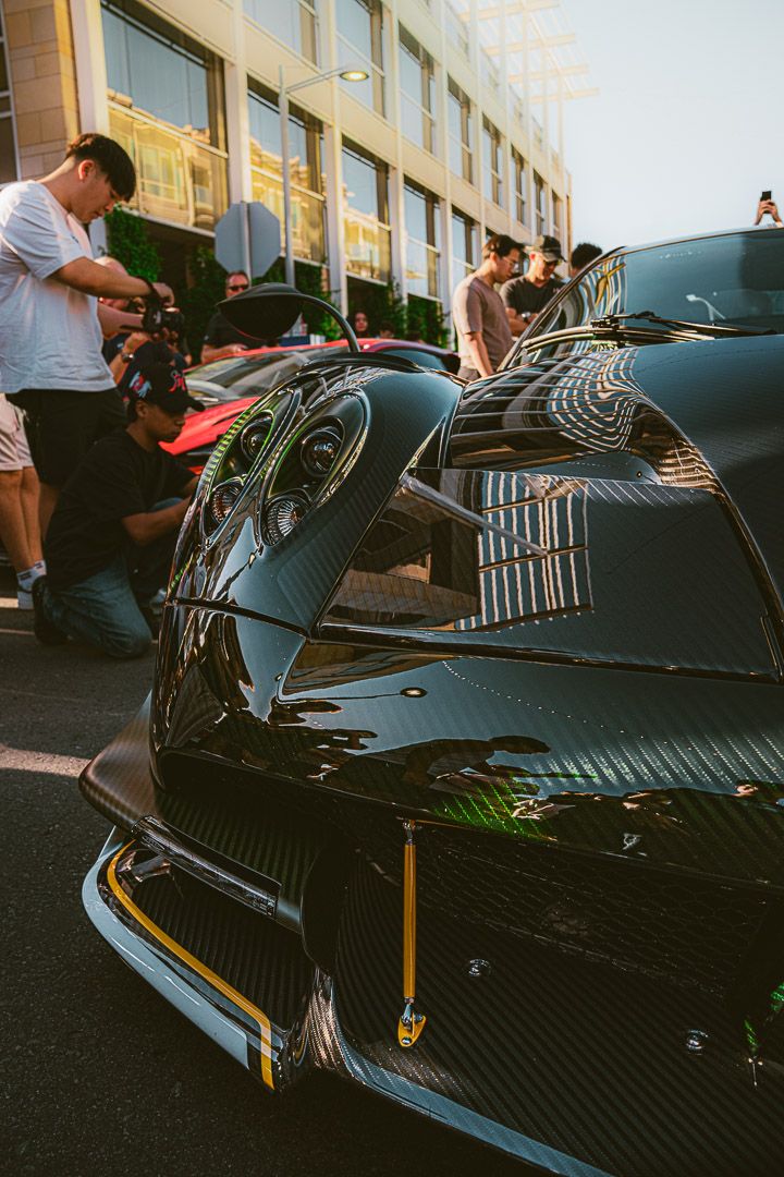 Close-up shots of a carbon fiber supercar body with detailed aerodynamic features and gold accents.