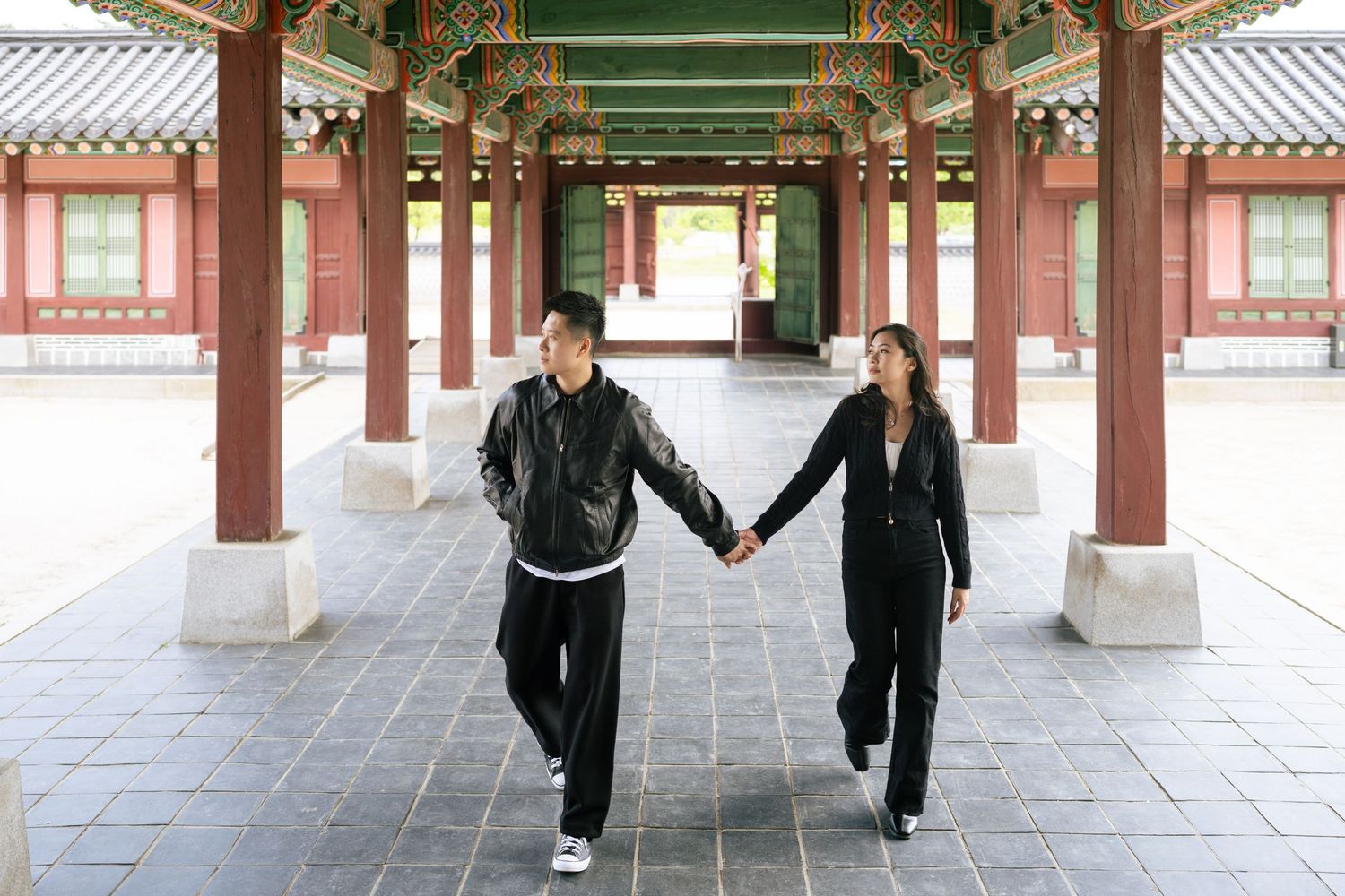 A panoramic view of people practicing martial arts in traditional Asian temple courtyard.