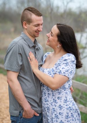 A couple in a grey shirt and floral dress share romantic moments together in a series of outdoor photos.
