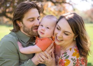 A family shares tender moments together outdoors during a golden hour photo session in autumn.