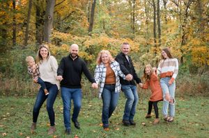 A series of candid walking shots showing people enjoying a stroll through vibrant autumn woods with golden leaves.
