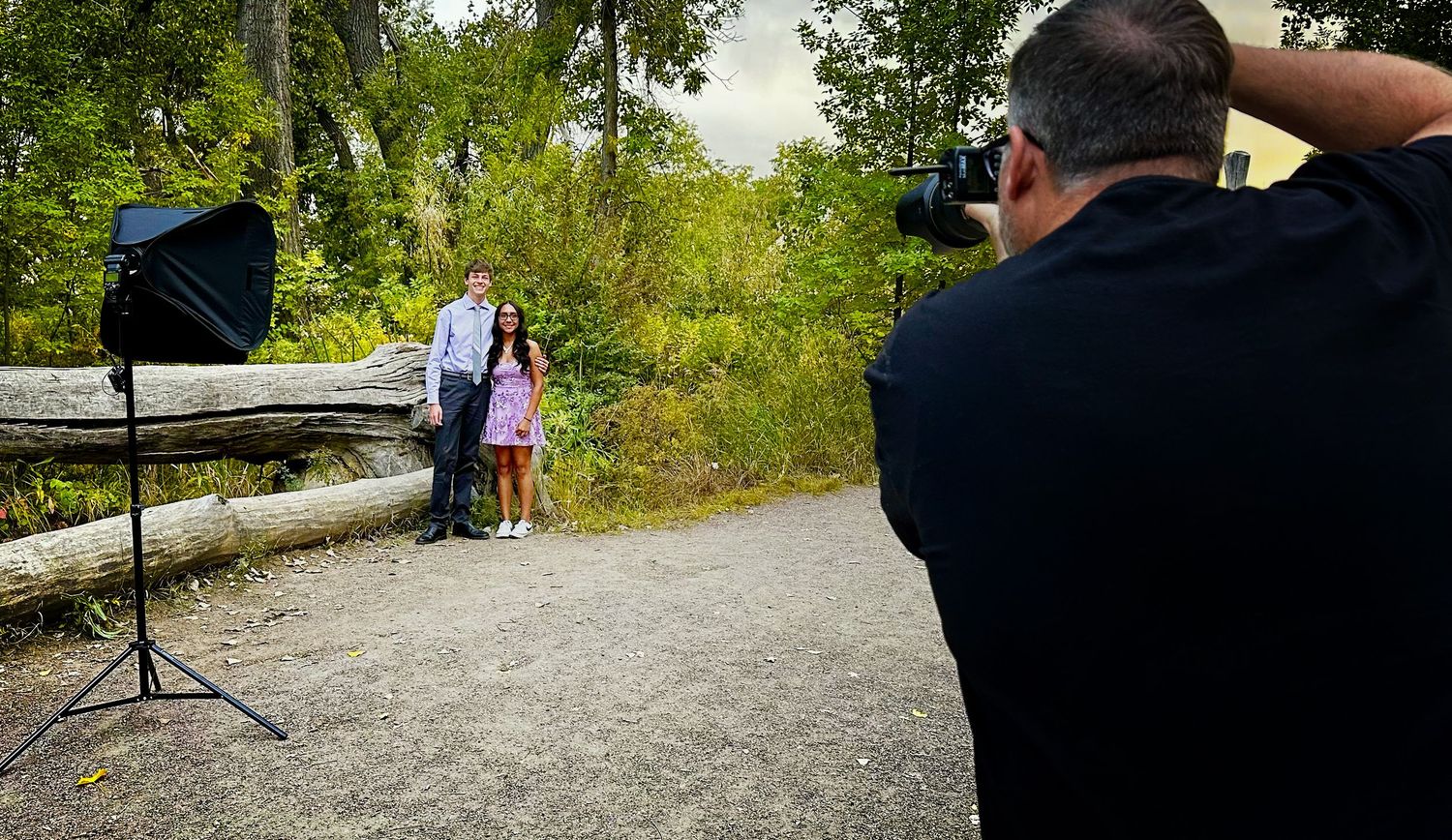 Behind-the-scenes view of a Ashley Bell Denver photographer shooting a portrait session outdoors.