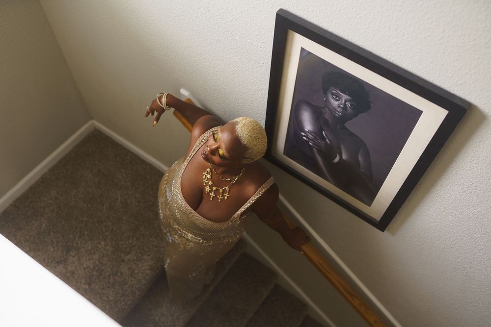 A series of framed artwork and decorative objects displayed along a wall in a home interior.