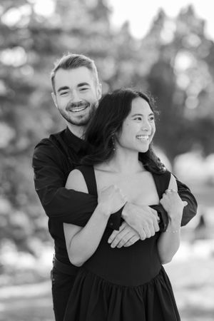 Romantic black and white portrait of couple embracing outdoors.