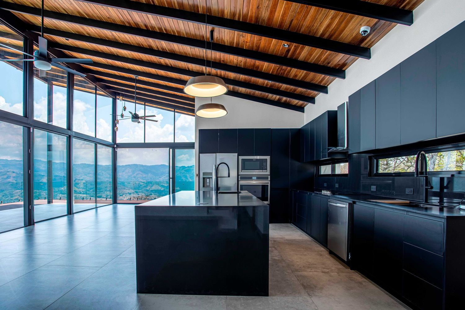 Spacious luxury kitchen with high wooden ceilings, natural light, and modern decor in a premium Costa Rica property
