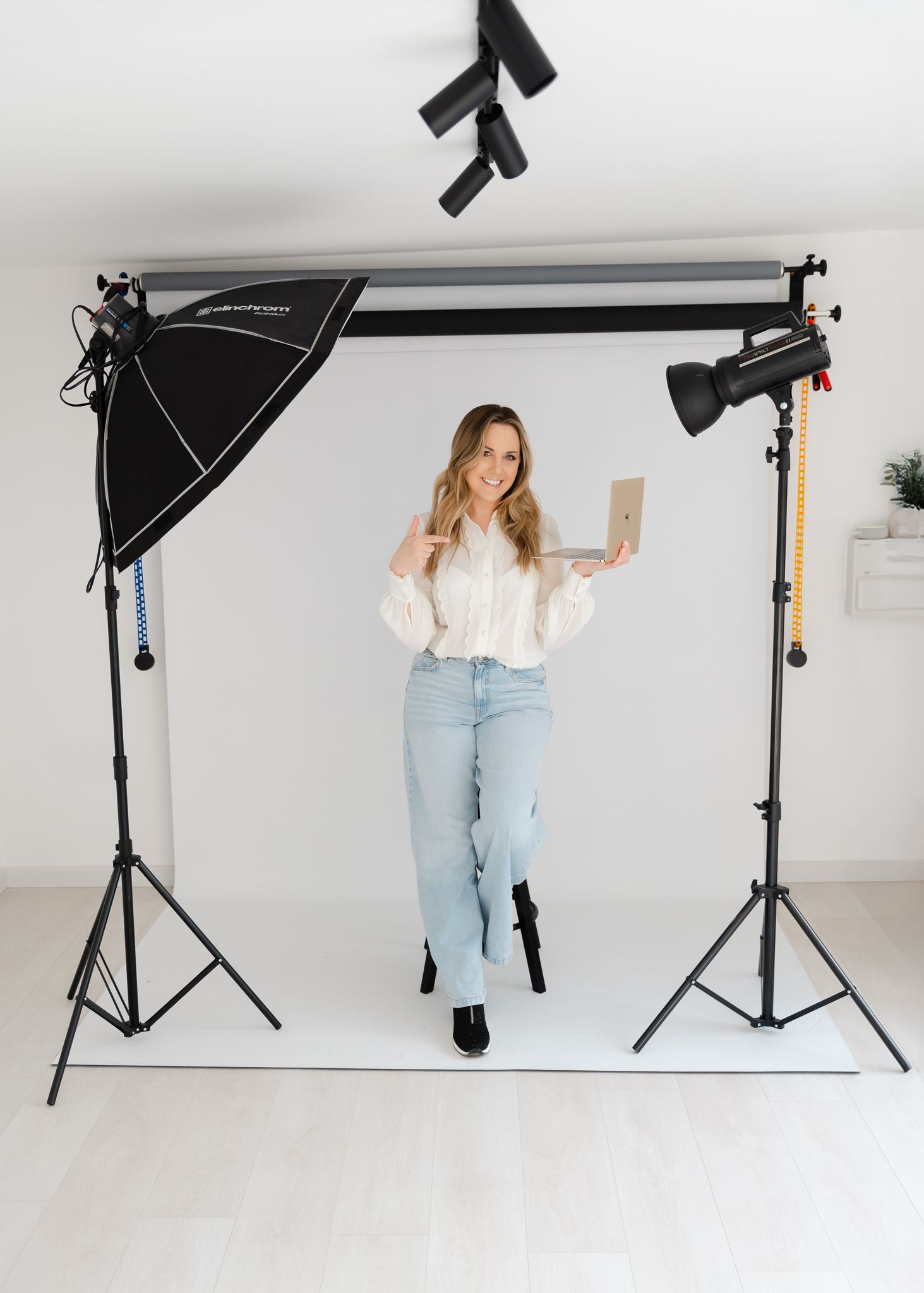 Professional photo studio setup with lighting equipment and backdrop against white wall for content creation photography.