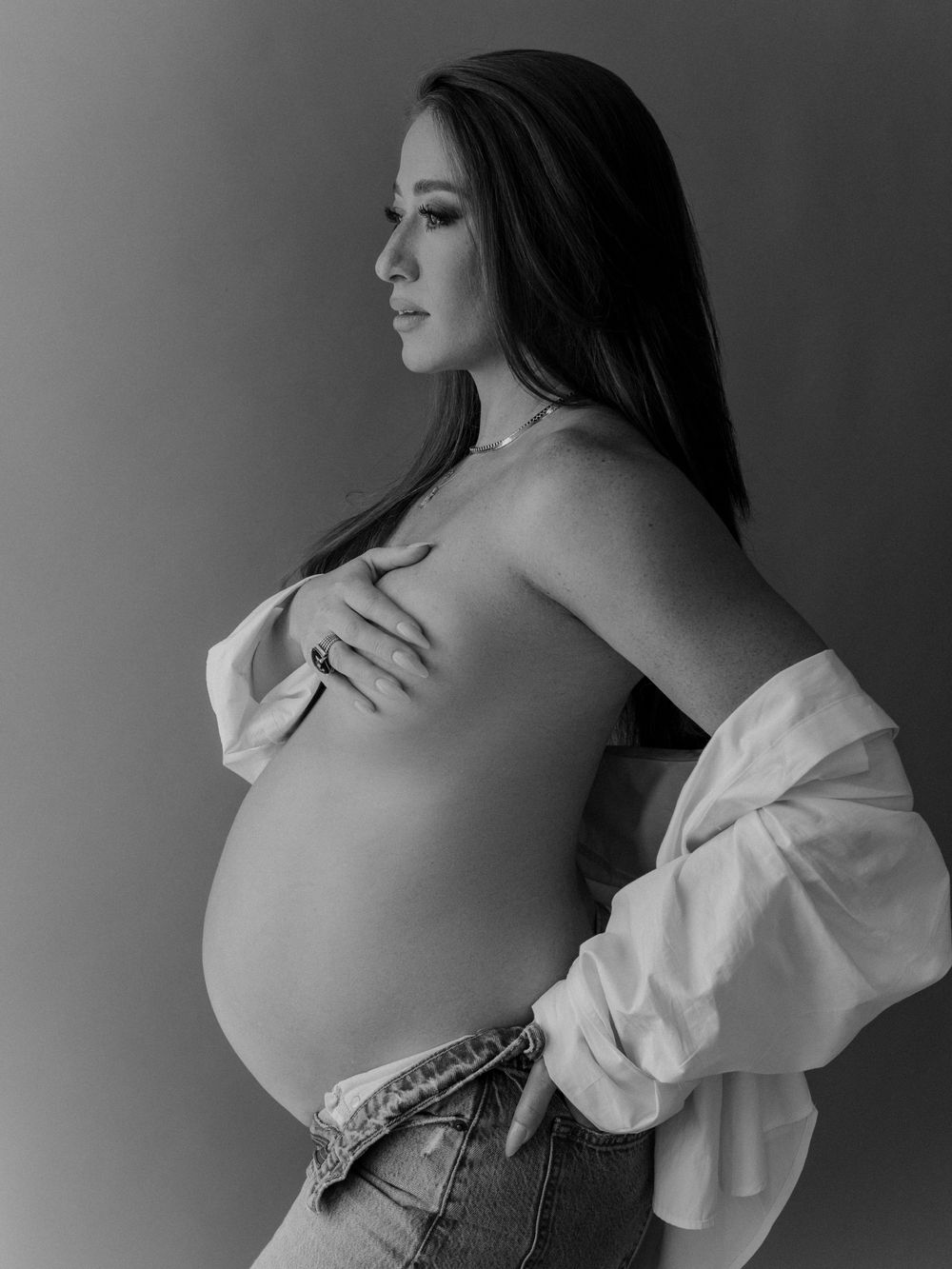 A black and white artistic maternity photo series showing a pregnant woman in profile wearing a white top.