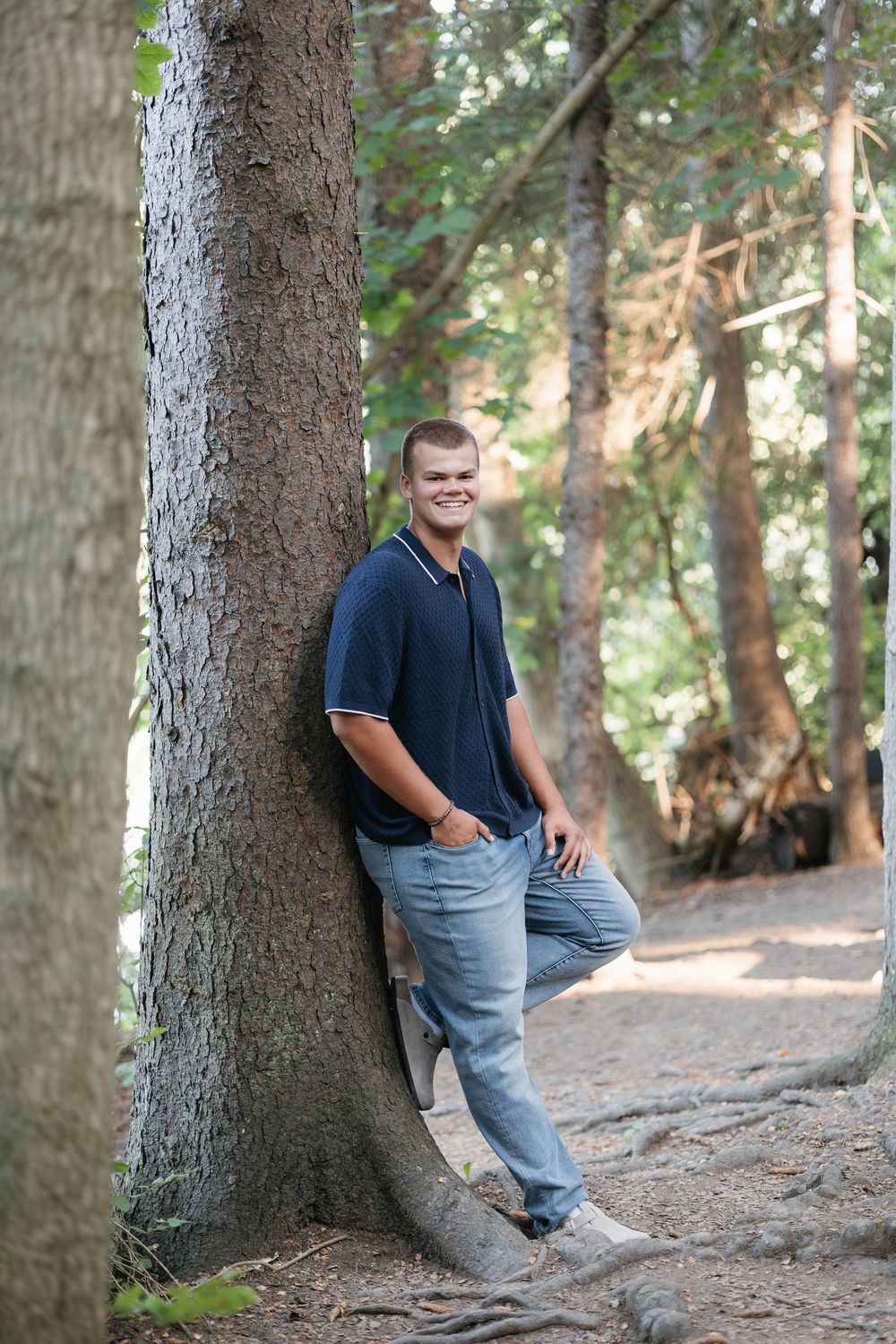 High school senior posing outdoors with confident smile