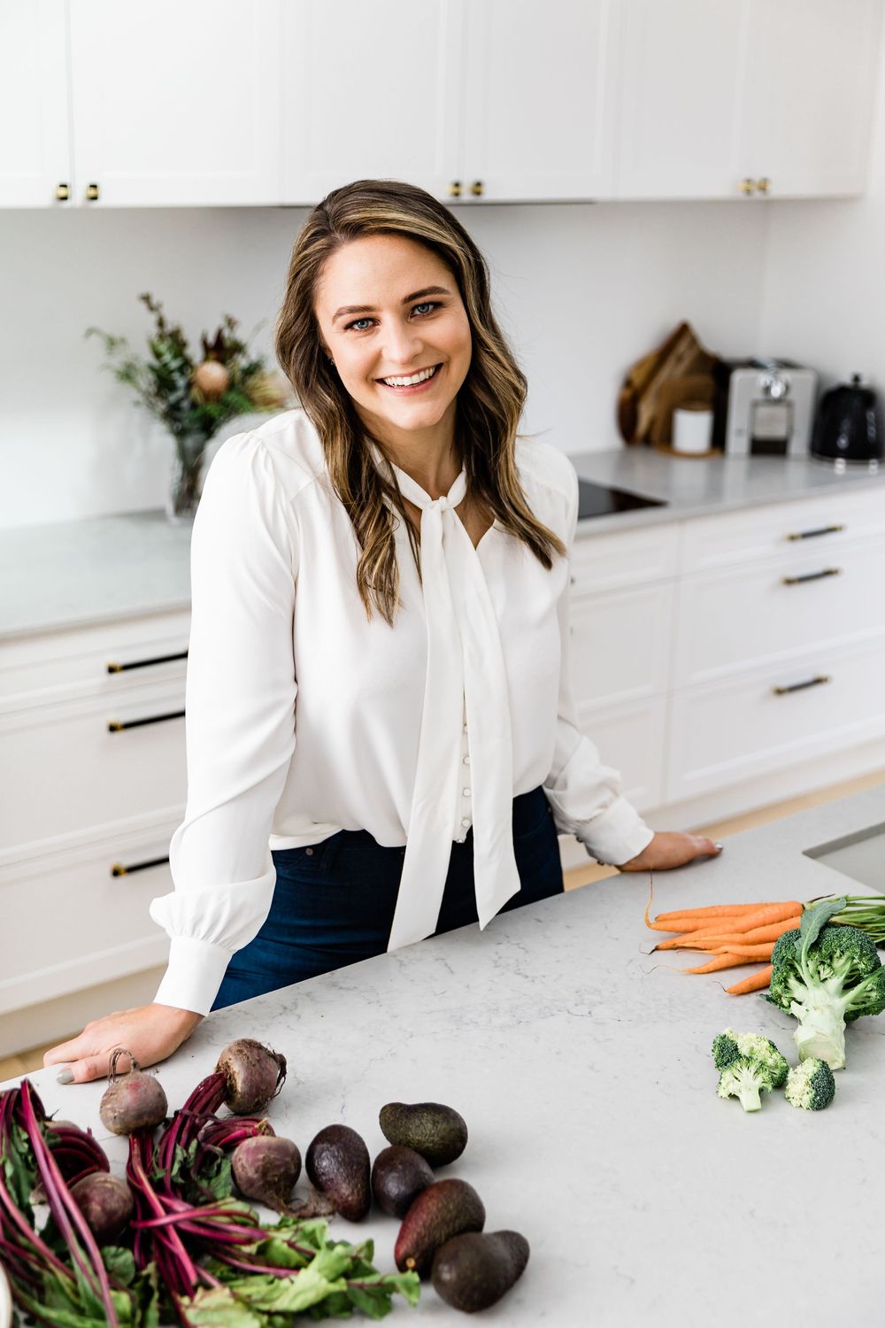 Professional lifestyle photos of fresh vegetables including beets and carrots being prepared on white kitchen counter.