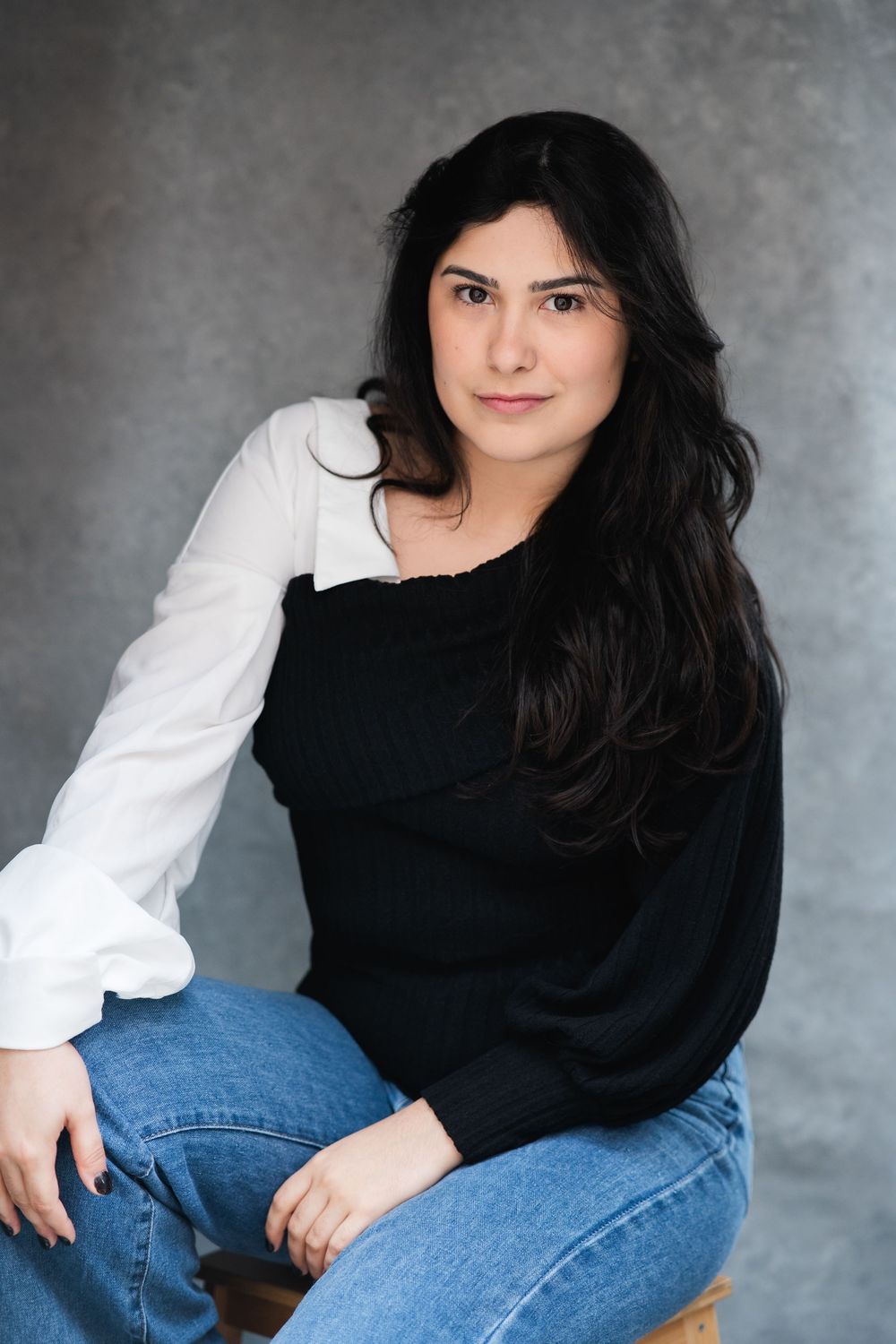 A series of casual portrait shots against a gray background featuring dark hair and a black and white outfit combination.
