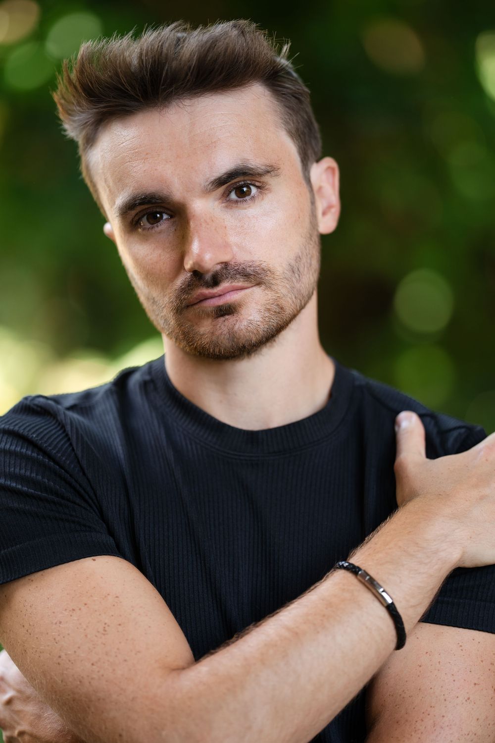 Portrait series showing close-up shots of someone wearing a black t-shirt against a blurred green outdoor background.