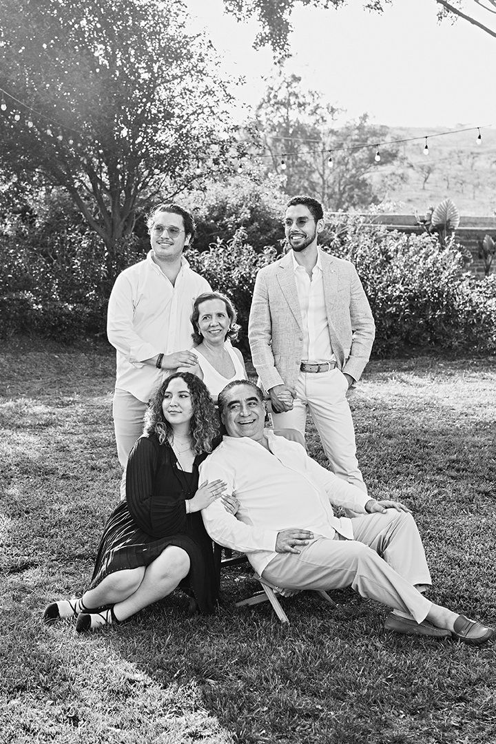 Black and white portrait of a family group relaxing together outdoors.