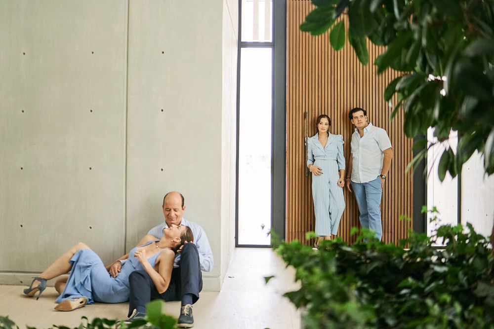 Contemporary interior scene with people lounging and standing in a minimalist space with plants.