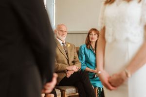 Wedding ceremony attendees seated indoors during an intimate celebration.