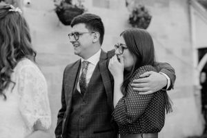 Black and white candid moment of emotional wedding guests.
