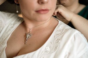 Close-up shots of delicate silver pendant necklaces on display against a white background.