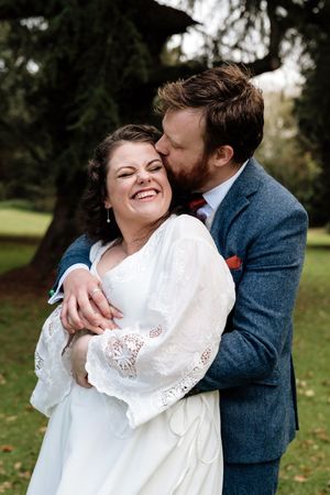 A couple shares intimate moments during their wedding photoshoot in an autumn park setting.