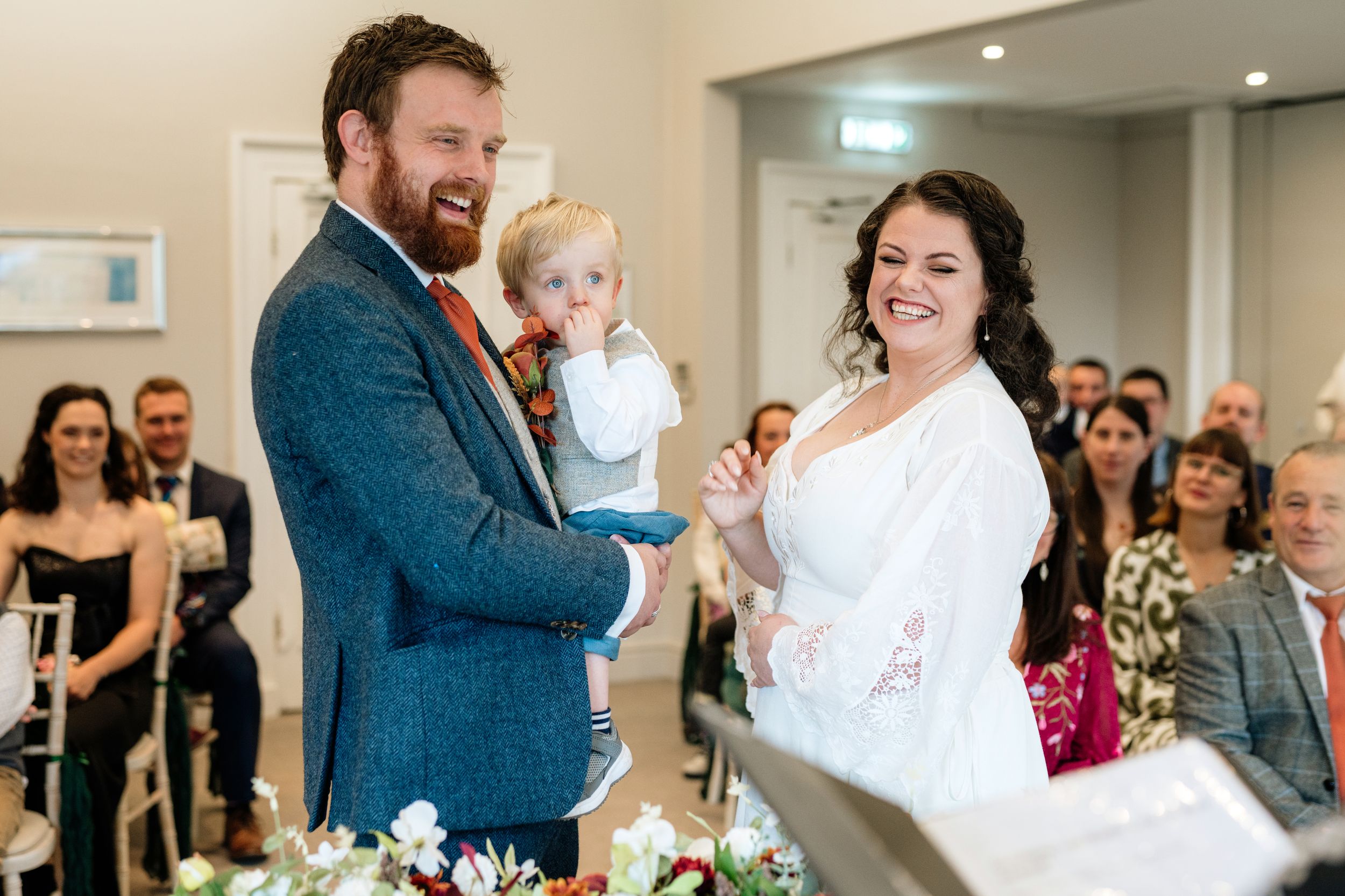A joyful wedding reception scene with guests dancing and celebrating in an elegant indoor venue.