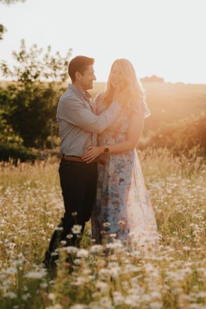 A romantic sunset photoshoot in a wildflower meadow filled with white daisies and golden light.