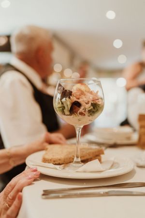 Elegant cocktail glasses and place settings at wedding reception tables.
