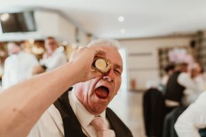 Joyful dancing couple in formal attire sharing laughter during their first dance at a wedding reception.