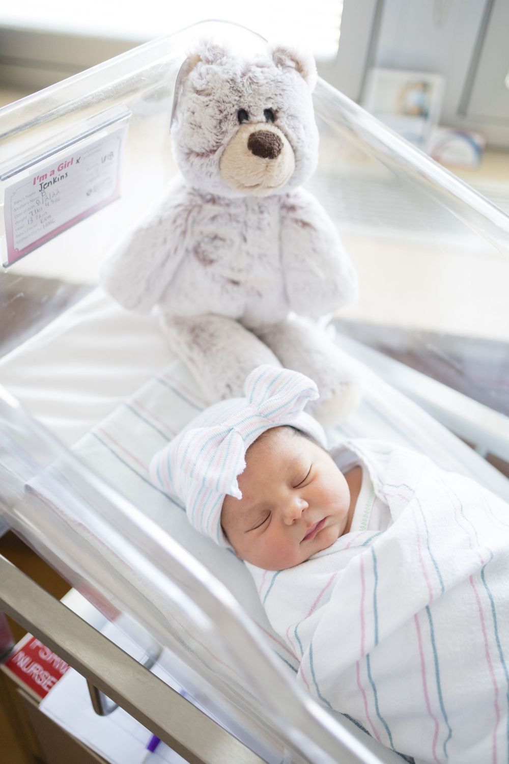 Newborn baby swaddled in striped blanket during her Fresh 48 session at Fort Sanders Medical Center in Knoxville.