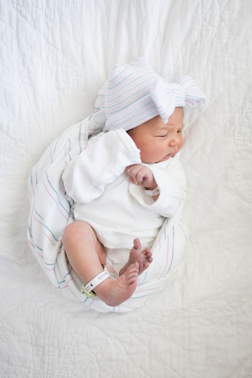 Newborn baby wrapped in striped blanket during her Fresh 48 session at Fort Sanders Medical Center in Knoxville.