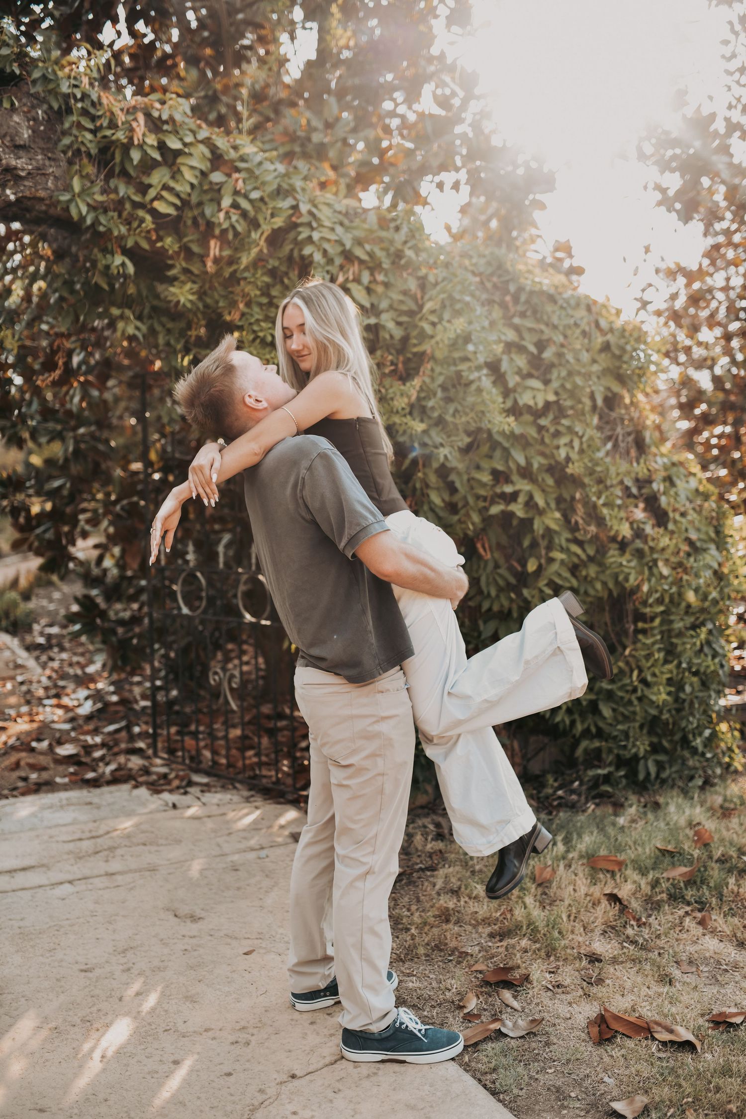 Surprise marriage proposal beneath a vine-covered garden arch
