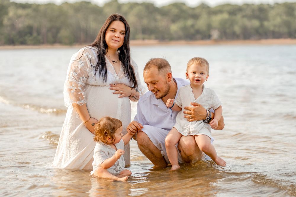 une famille partage un moment de complicité les pieds dans l'eau, au lac