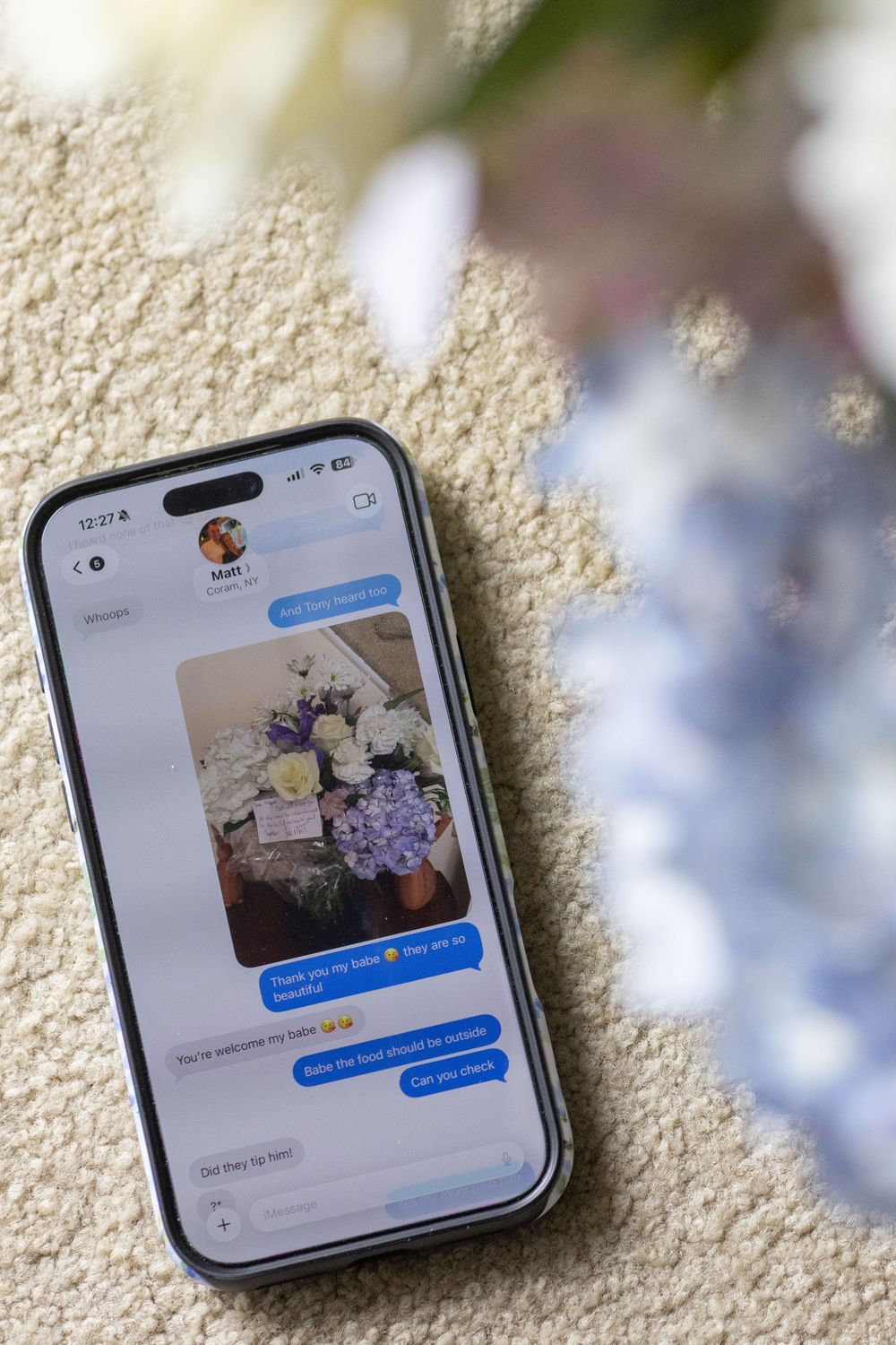 iPhone displaying iMessage conversation with photo of blue hydrangea and white rose flower arrangement.