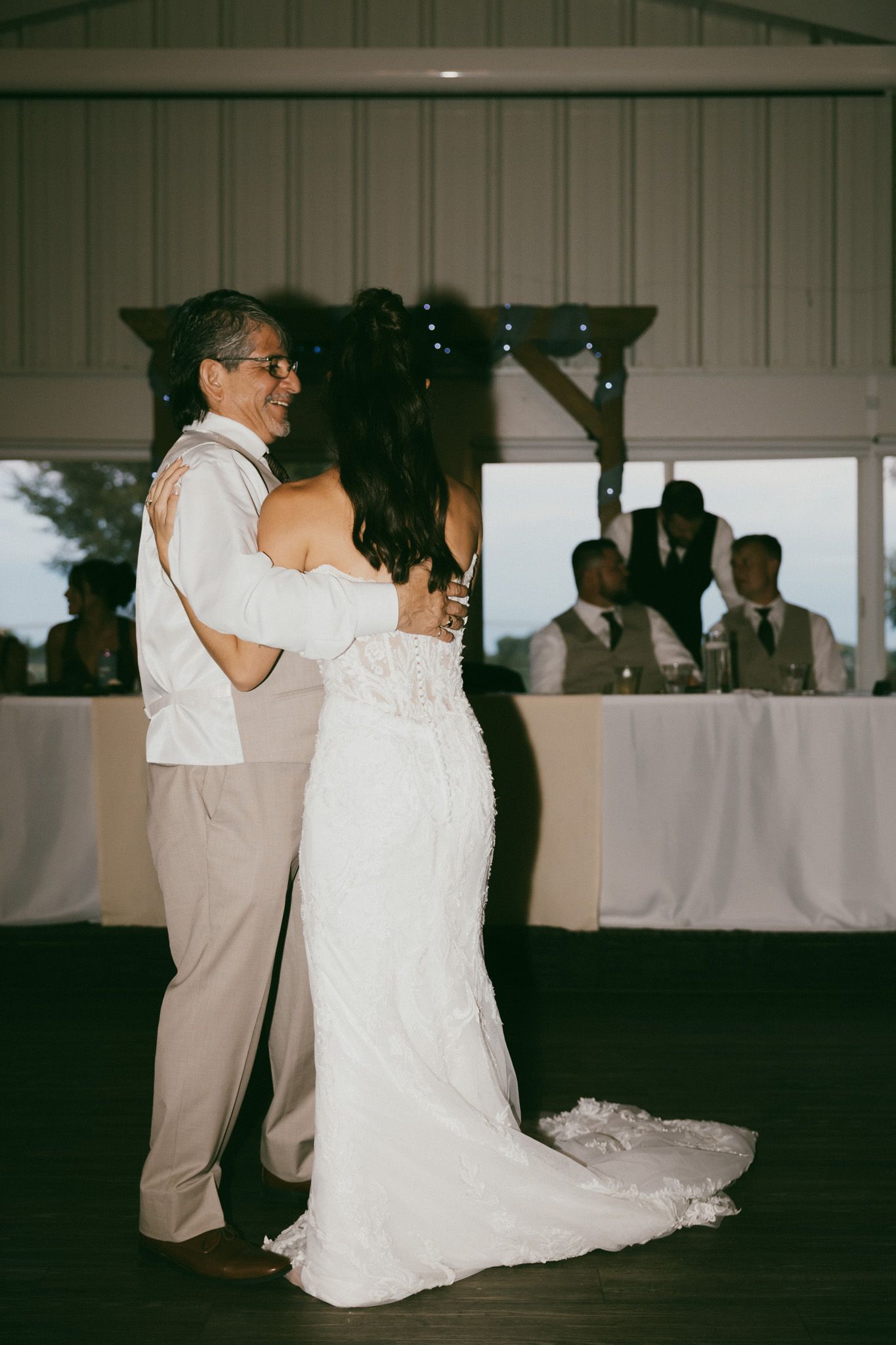 Bride and groom share their first dance in a decorated barn wedding reception venue.