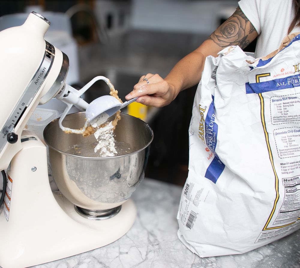 Sifting flour into the mixer for branding photos in Strongsville.