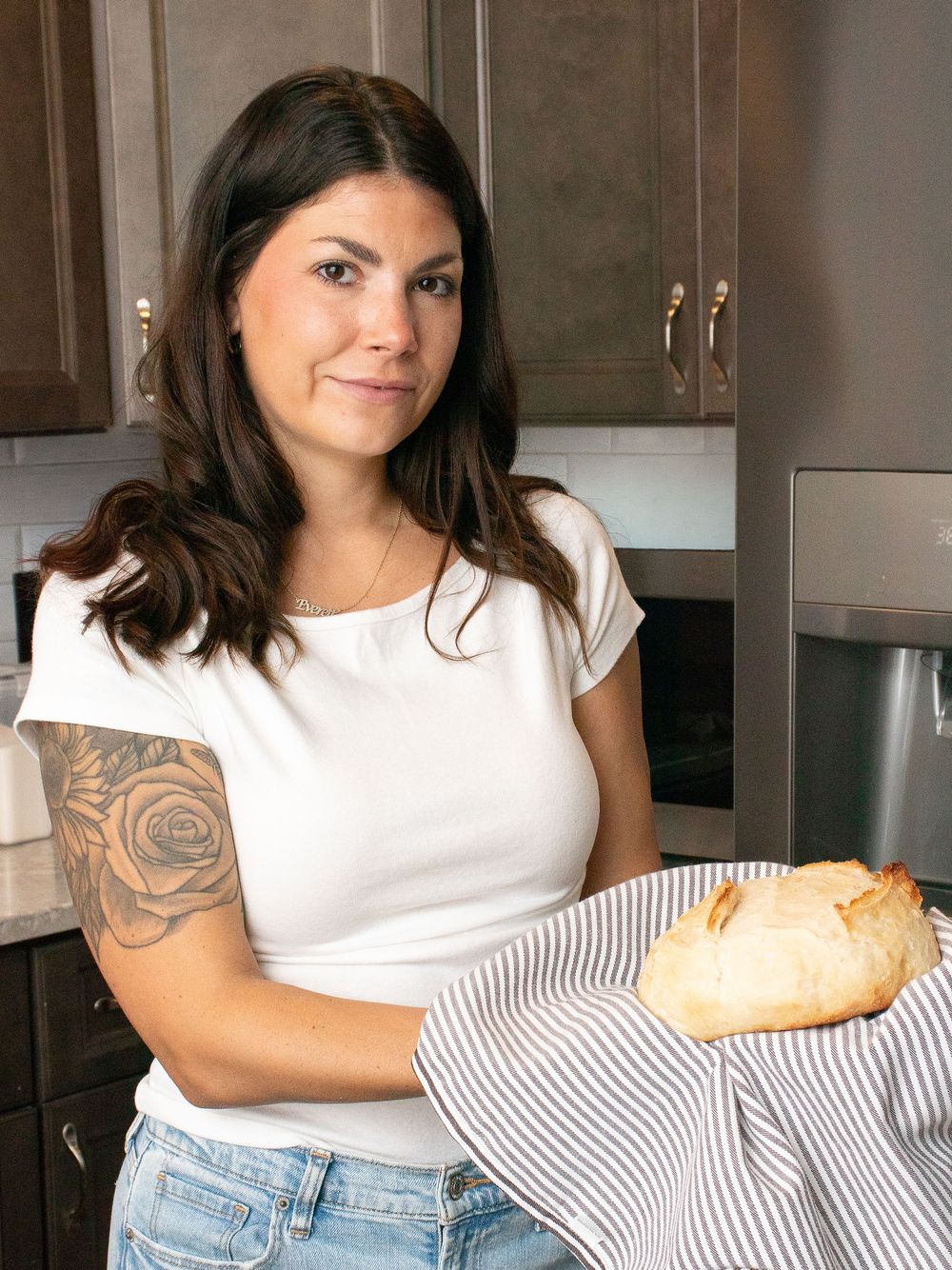 Woman smiling after taking a loaf of fresh bread from the oven for branding photos in Strongsville.