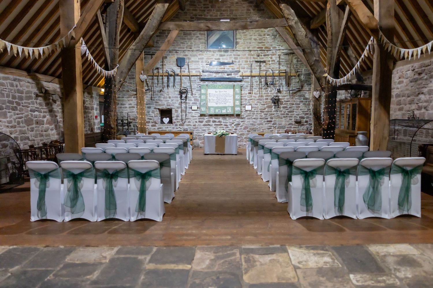 Whiston Manorial Barn - Rustic barn wedding venue with stone walls, and bunting decorations in a charming countryside setting.