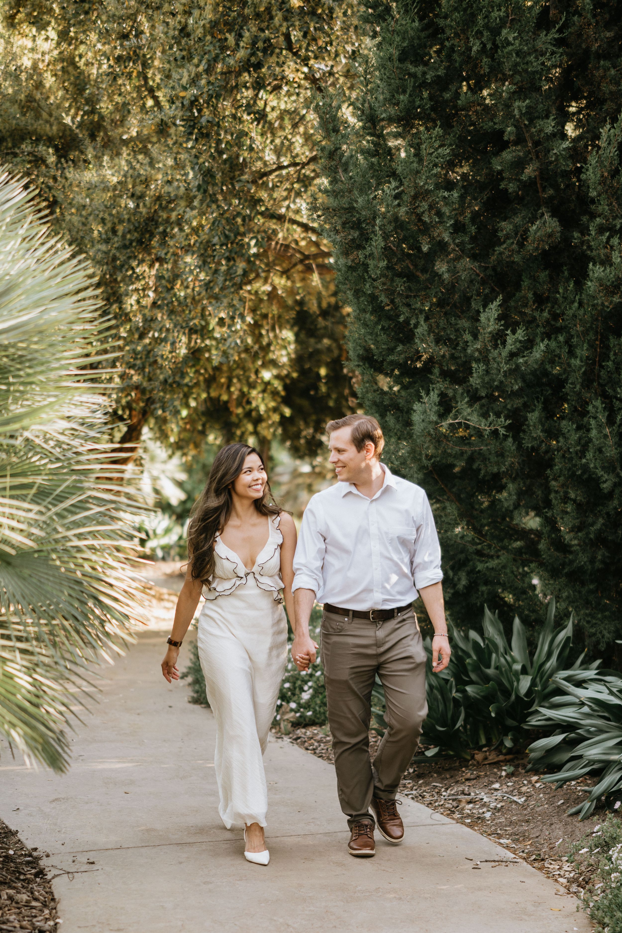 Mariel and Jeff walking hand in hand through the Los Angeles County Arboretum.