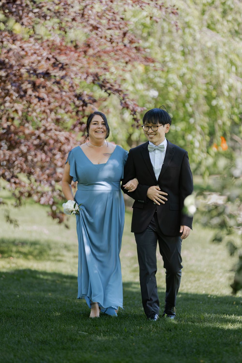 Bridesmaid and groomsmen surrounded by greenery at an outdoor ceremony at the civic garden complex in london, ontario.