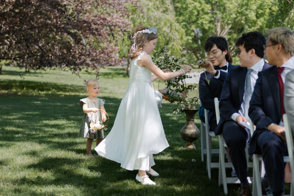 Flower girls handing out flowers during an outdoor ceremony under the trees at the civic garden complex in london, ontario.
