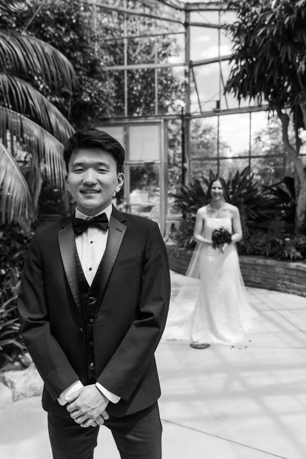 Black and white photo of groom and bride during first look in the conservatory at the civic garden complex in london, ontario.