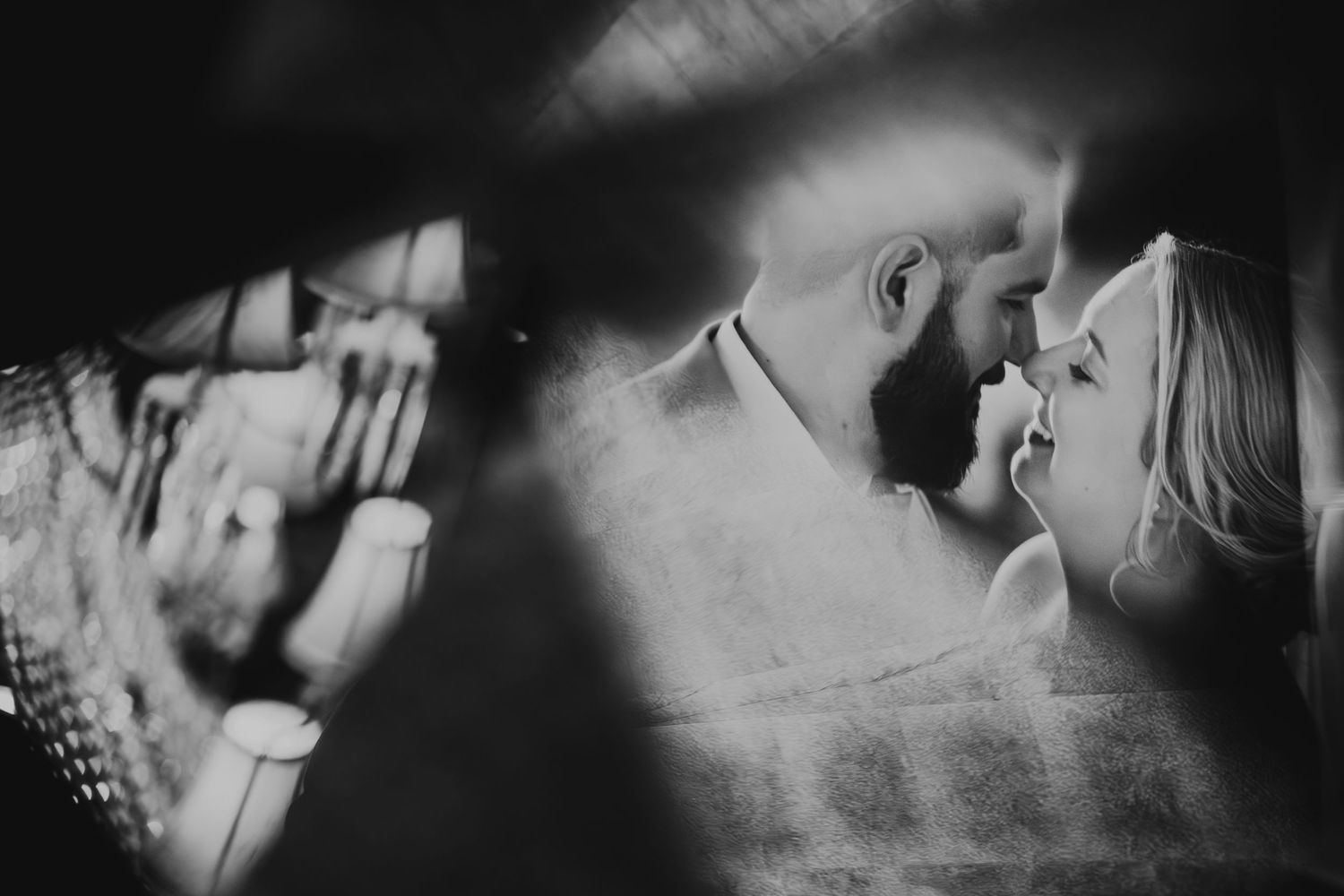 Romantic black and white photo of bride and groom sharing an intimate moment before their first kiss.