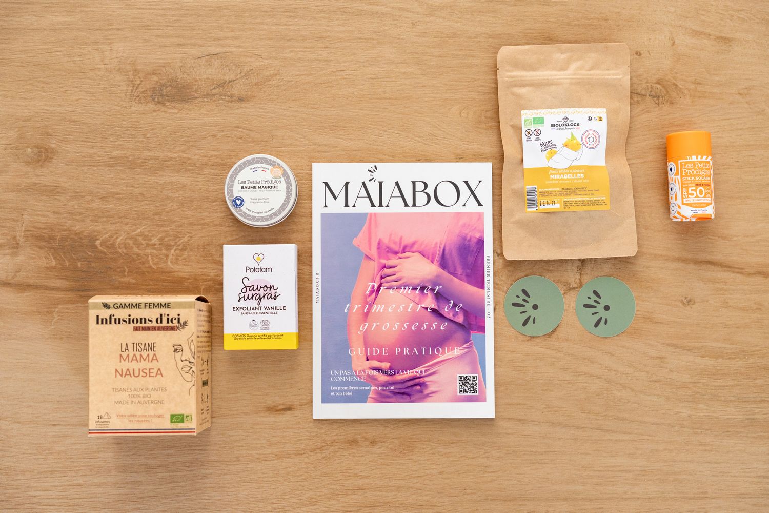 Maiabox pregnancy wellness subscription box with natural products and magazine on wooden surface.