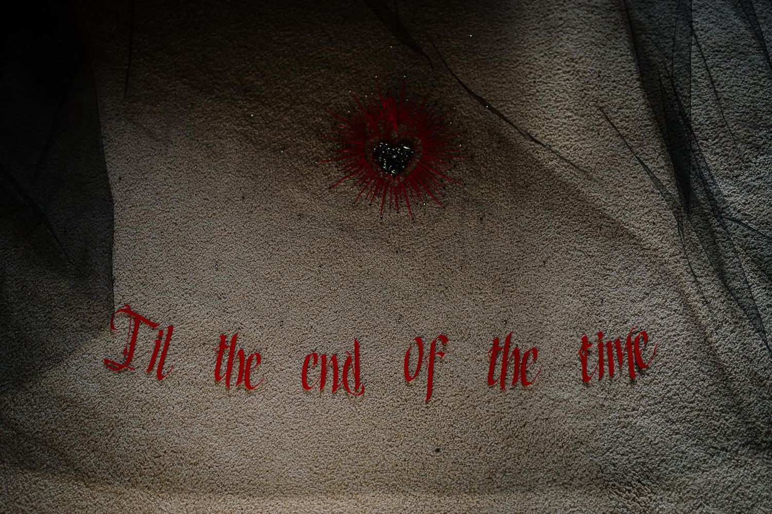 Black wedding veil embroidered with a red heart and the words Til the end of the time for a gothic Halloween wedding